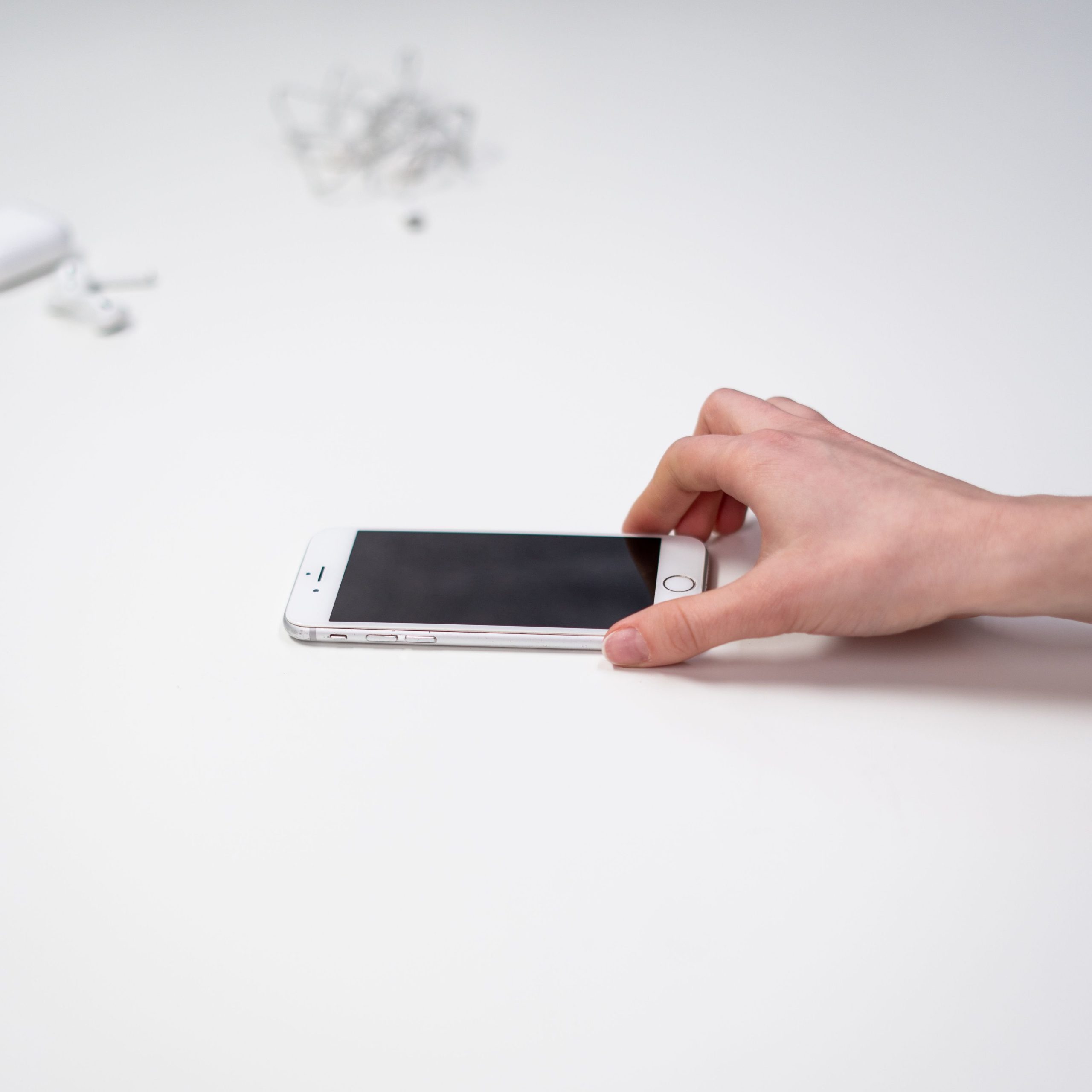 Une main pose un téléphone sur une surface